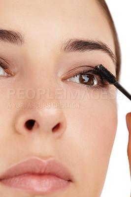 Buy stock photo Cropped shot of a beautiful young woman applying mascara against a white background