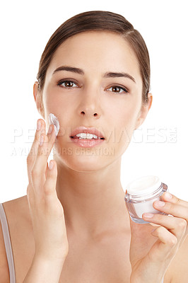 Buy stock photo Cropped portrait of a beautiful young woman applying moisturizer against a white background