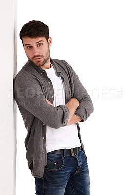 Buy stock photo Studio shot of a serious young man standing with his arms folded
