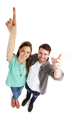 Buy stock photo High-angle shot of a happy young couple in studio raising their arms and pointing up