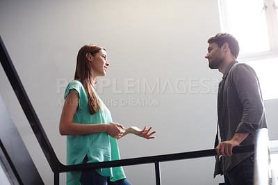 Buy stock photo Shot of two people having a conversation in a stairwell