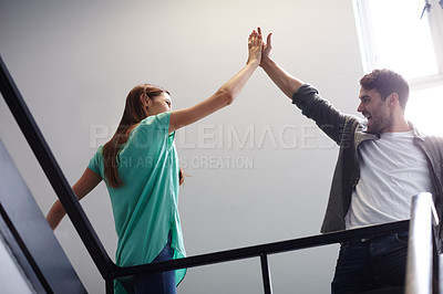 Buy stock photo Shot of two people giving each other a high five in a stairwell