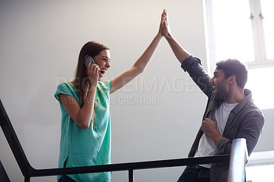 Buy stock photo Shot of an ecstatic woman on her phone giving a high five to her excited friend