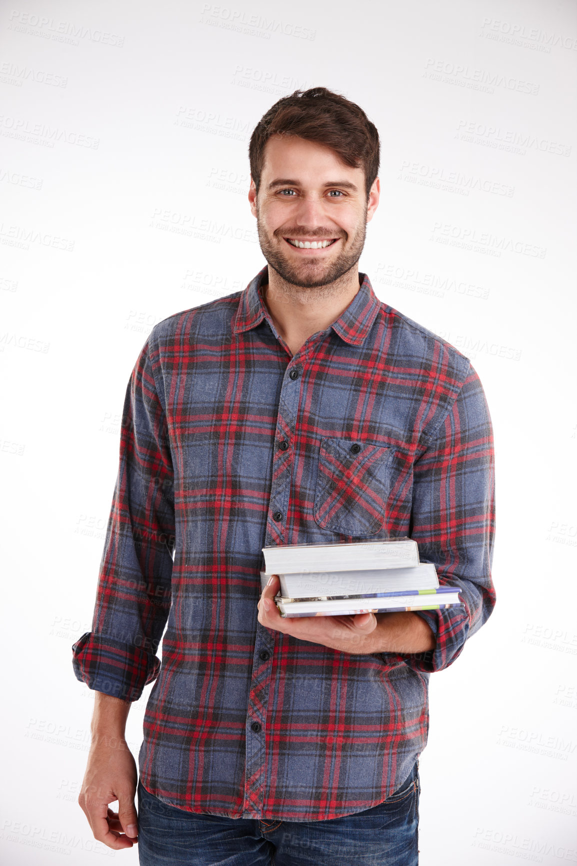 Buy stock photo Studio portrait of a smiling young man holding a pile of books in one arm