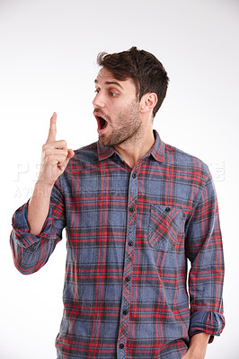 Buy stock photo Studio shot of a young man looking with surprise at his finger