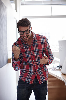 Buy stock photo Shot of an ecstatic young designer pumping his fists in victory