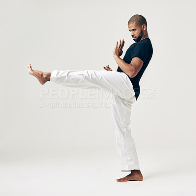 Buy stock photo Man, studio and martial arts for kick exercise, action and karate training on white background. Black male person, mockup space and practice for combat, fight and position of attack in taekwondo