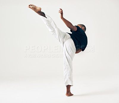 Buy stock photo Man, studio and martial arts for kick fight, action and karate exercise on white background. Black male person, mockup space and training for combat, fitness and position of attack in taekwondo
