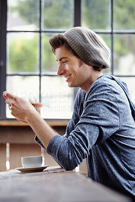 Buy stock photo Coffee shop cafe, smartphone and happy man reading, texting or check email, phone notification or social network. Gen z, morning diner and relax person smile, happiness and typing blog on mobile app