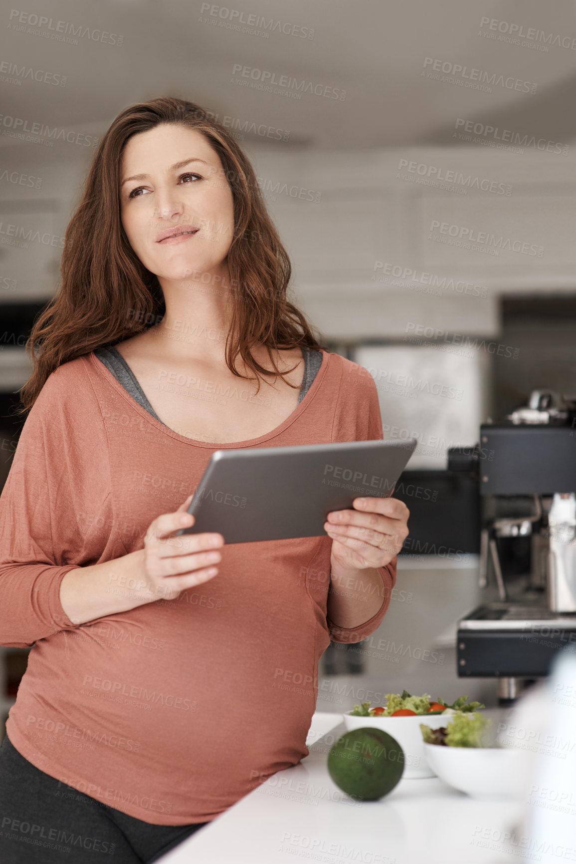 Buy stock photo Tablet, pregnancy and woman in kitchen at house for healthy, wellness and diet recipe. Digital technology, prenatal care and pregnant female person reading maternity blog for nutrition research.