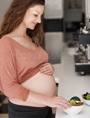 Buy stock photo Cropped shot of a young pregnant woman eating a salad in the kitchen