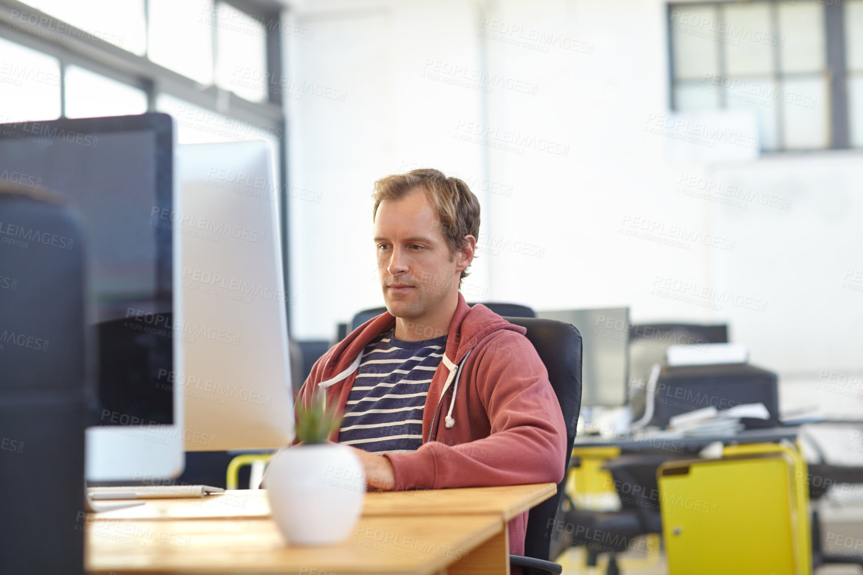 Buy stock photo Shot of a designer at work on a computer in an office