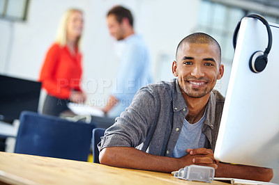 Buy stock photo Portrait of a designer at work on a computer with colleagues in the background