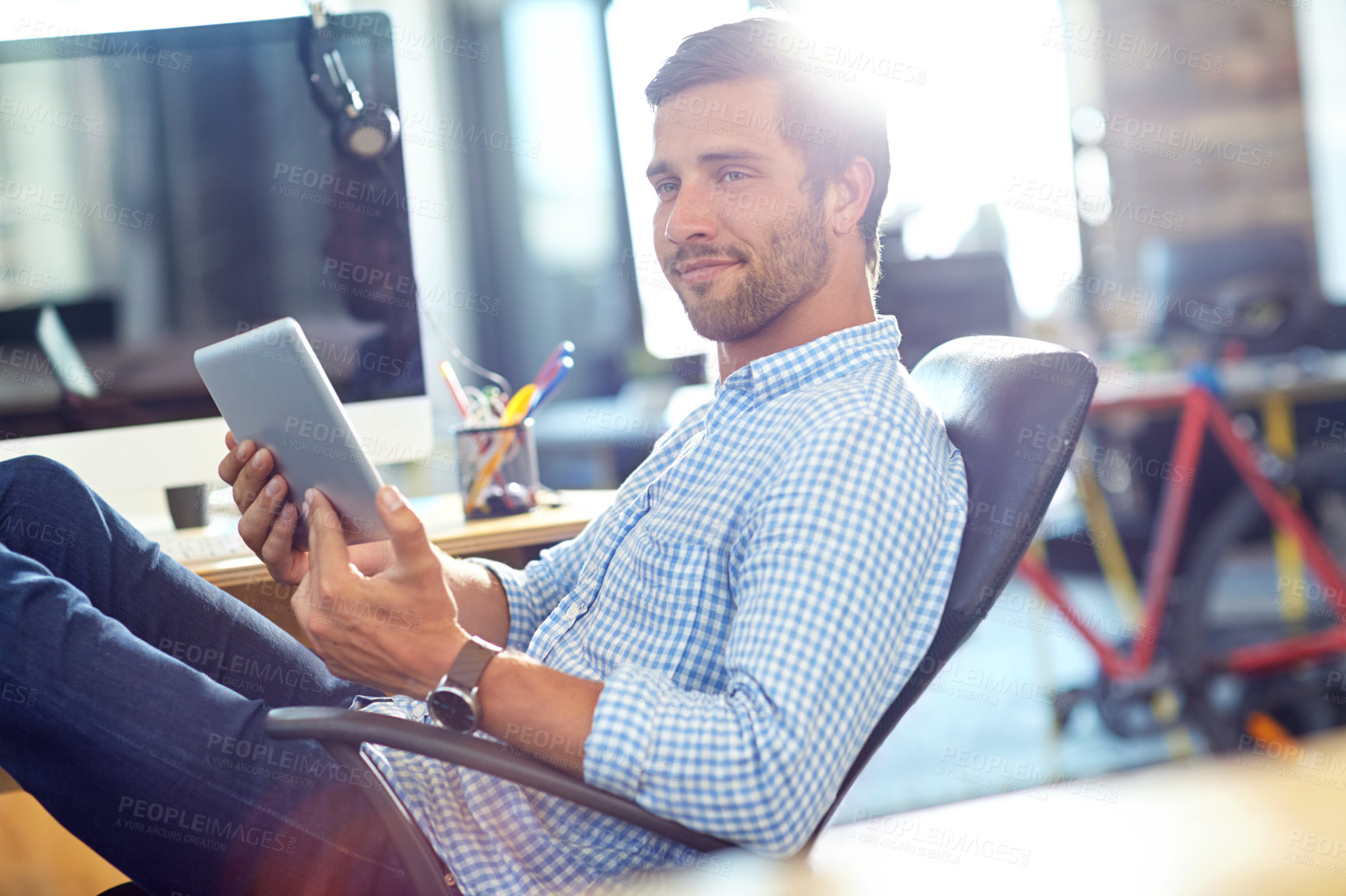 Buy stock photo Shot of a designer using a digital tablet while working in an office