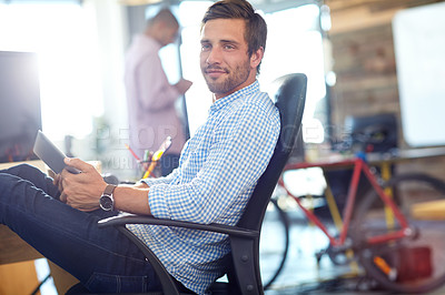 Buy stock photo Shot of a designer using a digital tablet while working in an office