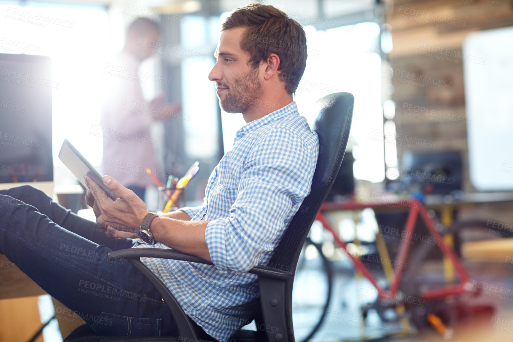 Buy stock photo Shot of a designer using a digital tablet while working in an office