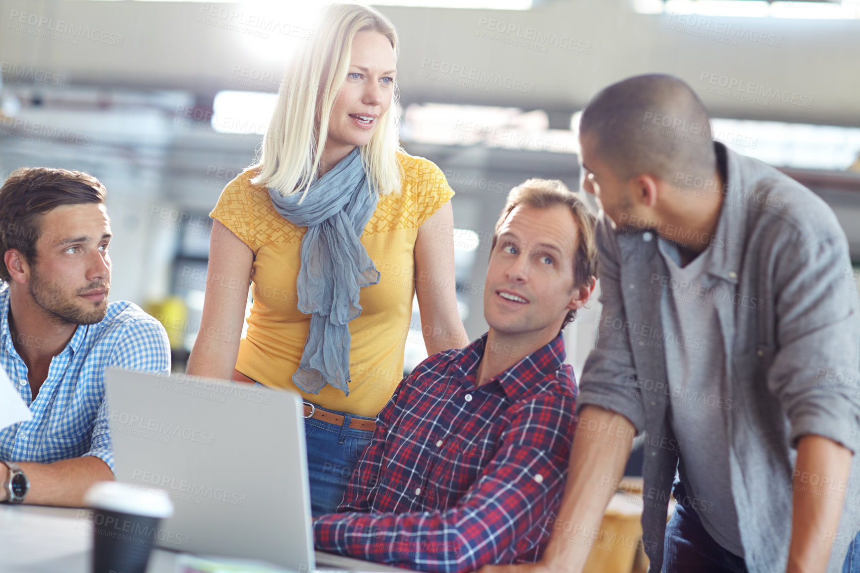 Buy stock photo Shot of a diverse group of designers working on a laptop in an office