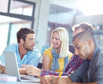 Buy stock photo Shot of a diverse group of designers working on a laptop in an office