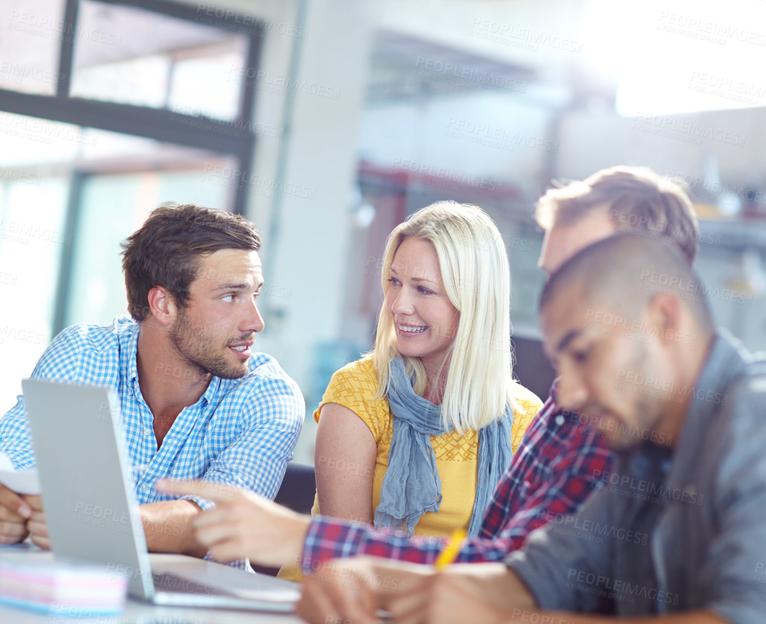 Buy stock photo Shot of a diverse group of designers working on a laptop in an office