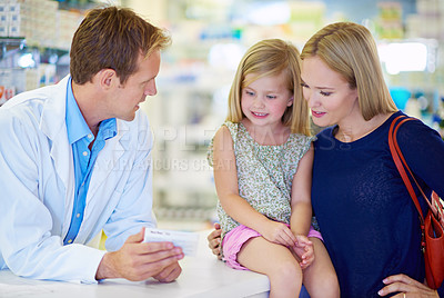 Buy stock photo A pharmacist giving medication to a mother and daughter