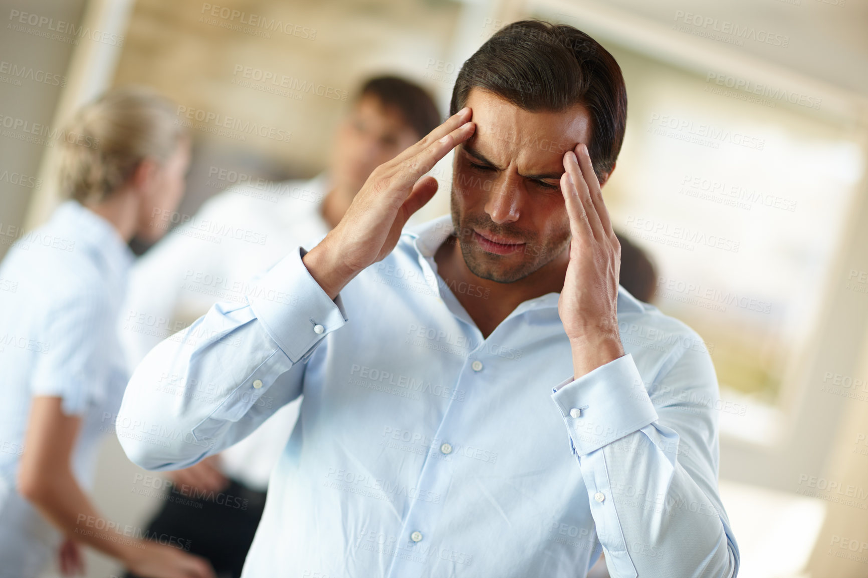 Buy stock photo Shot of a businessman suffering from a headache at the office