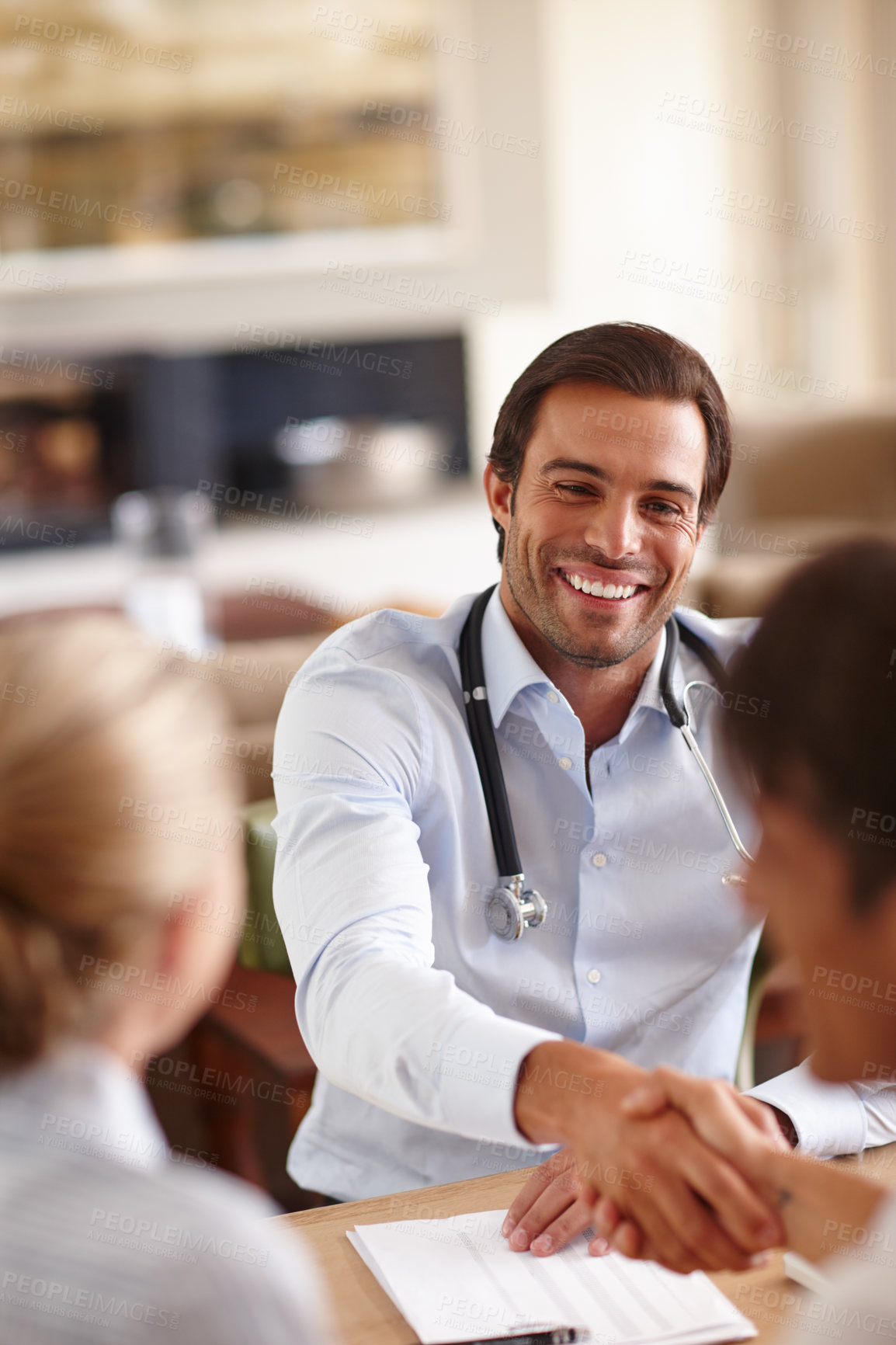 Buy stock photo Shot of a male doctor shaking hands with a patient