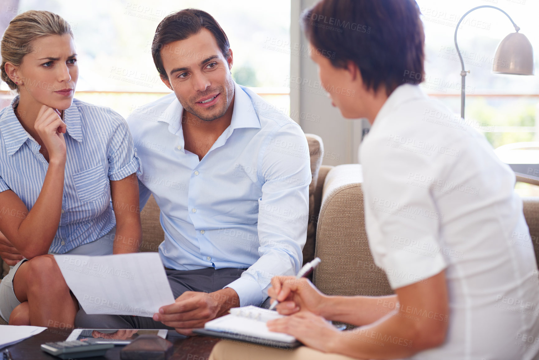 Buy stock photo Shot of a couple meeting with their financial advisor at home