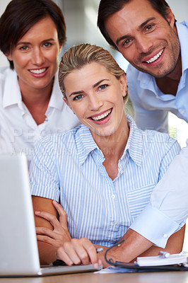 Buy stock photo Portrait of a group of business colleagues huddled by  a laptop