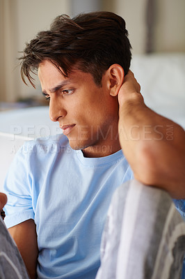 Buy stock photo Cropped shot of a handsome young man rubbing the back of his neck