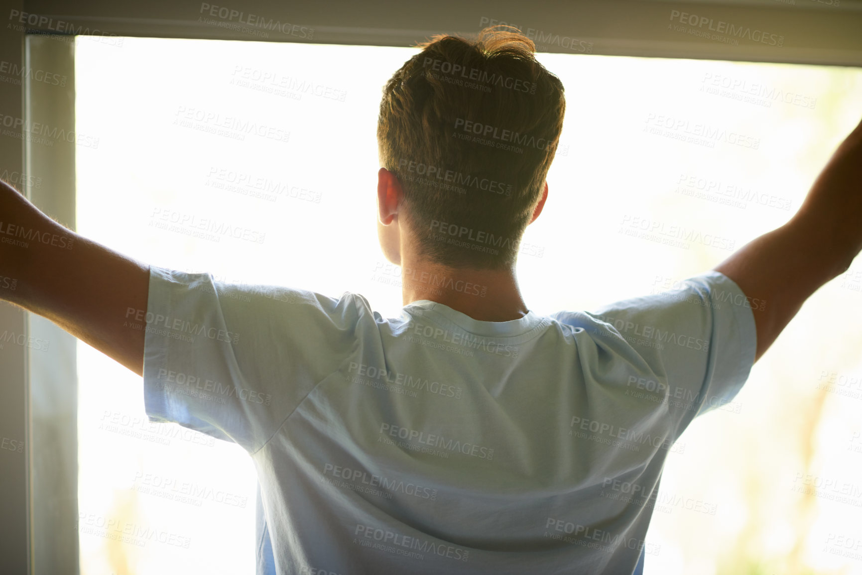 Buy stock photo Rearview shot of a man opening his curtains to look at the view outside