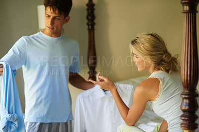 Buy stock photo Shot of a young man asking his wife advice on what to wear