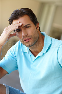 Buy stock photo Shot of a man suffering from a headache touching his forehead