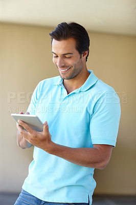 Buy stock photo Shot of a handsome man using a digital tablet indoors