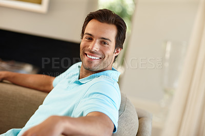 Buy stock photo Portrait of a handsome man smiling while sitting on the sofa at home