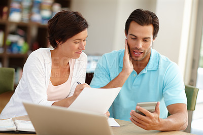 Buy stock photo Shot of a couple sitting with a laptop busy doing budget calculations