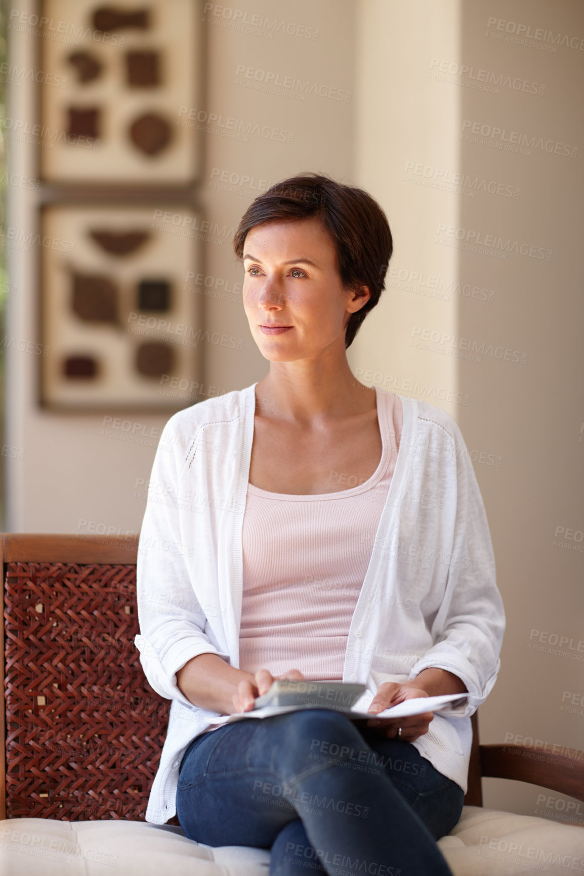 Buy stock photo Shot of an attractive woman sitting with documents and a calculator at home