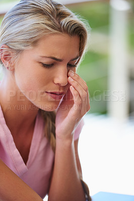 Buy stock photo Cropped shot of a young woman looking sad while sitting indoors