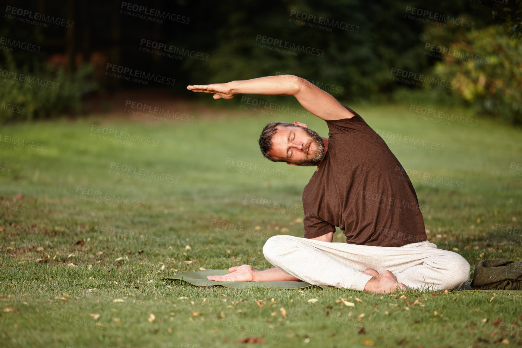 Buy stock photo Shot of a handsome mature man doing yoga in the outdoors