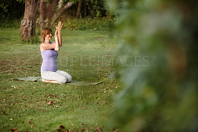 Buy stock photo Shot of an attractive woman doing yoga at the park