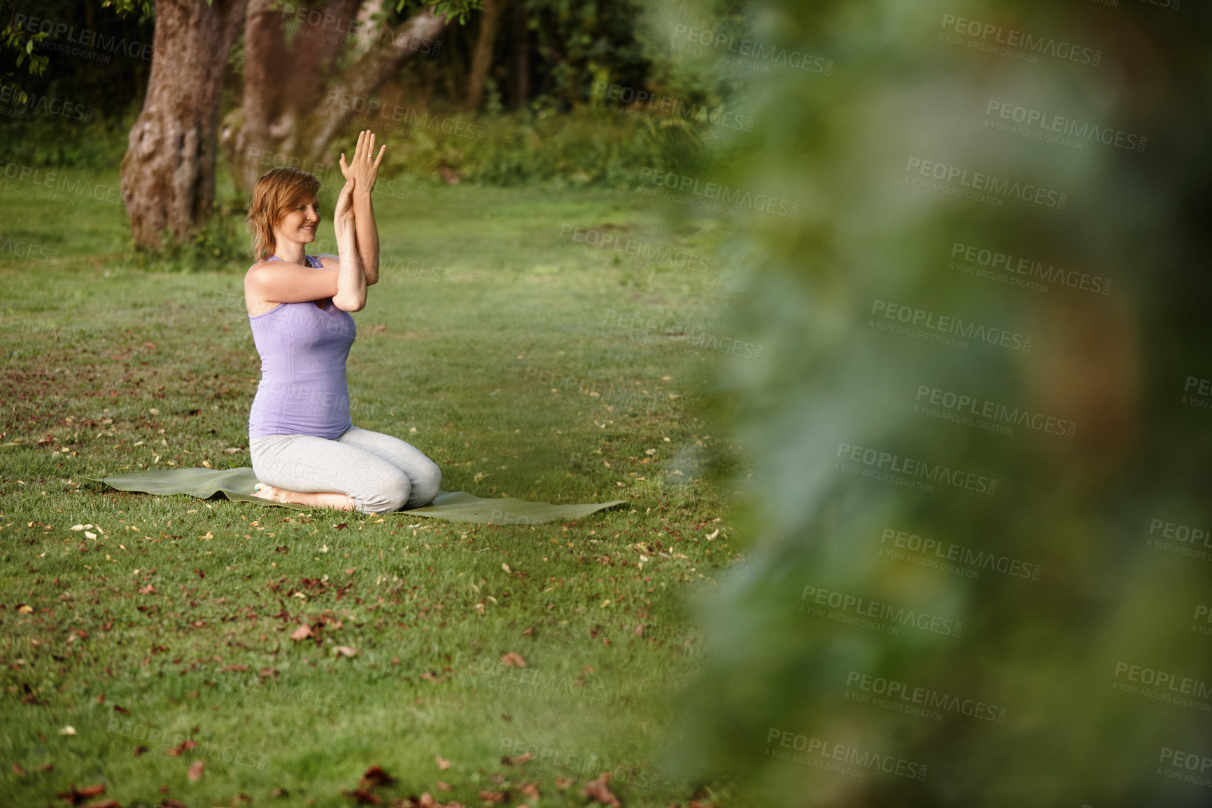 Buy stock photo Shot of an attractive woman doing yoga at the park