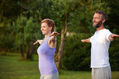 Buy stock photo Shot of a happy mature couple doing yoga in nature