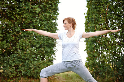 Buy stock photo Shot of an attractive woman enjoying a yoga session in the outdoors