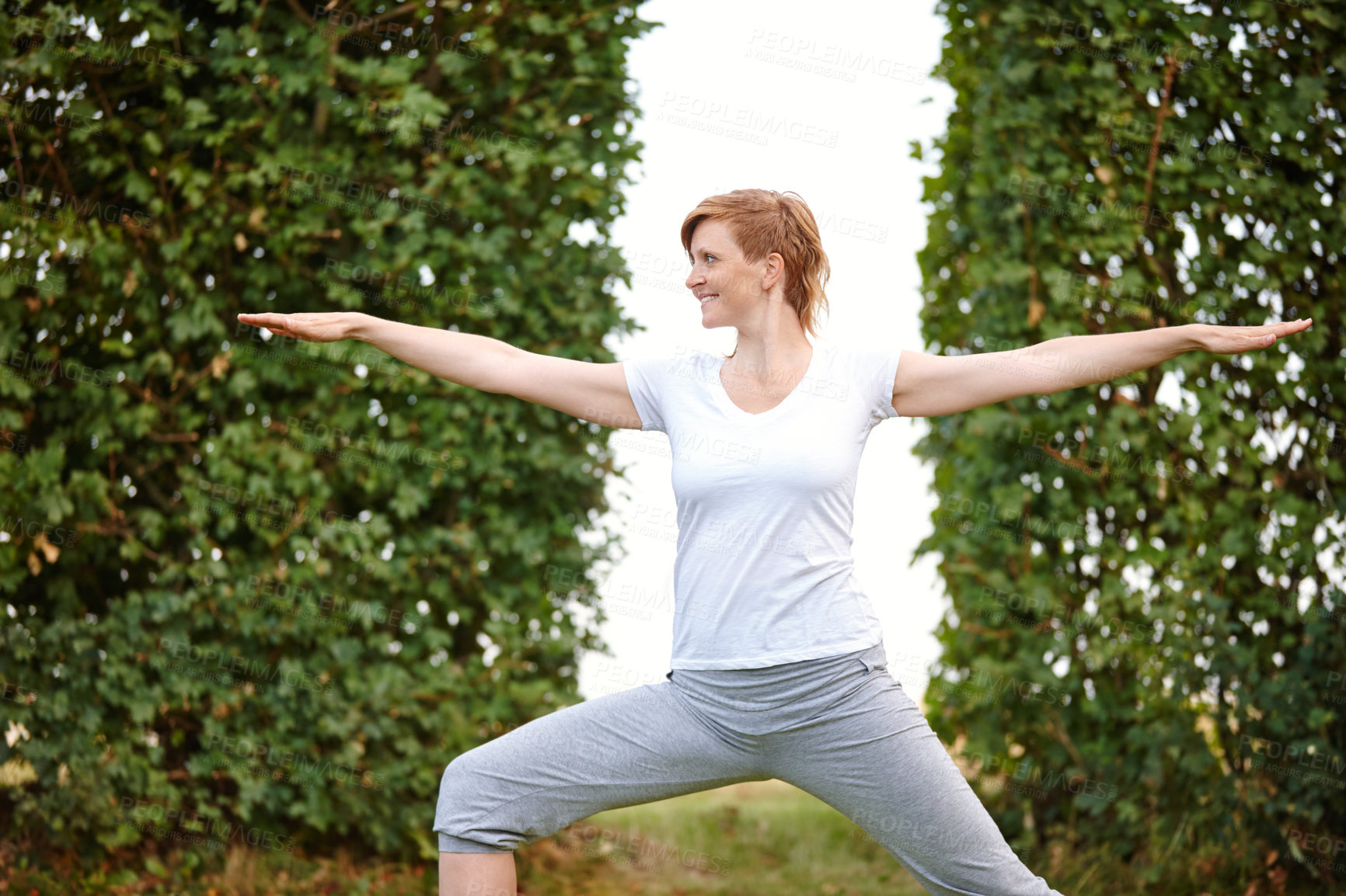 Buy stock photo Shot of an attractive woman enjoying a yoga session in the outdoors