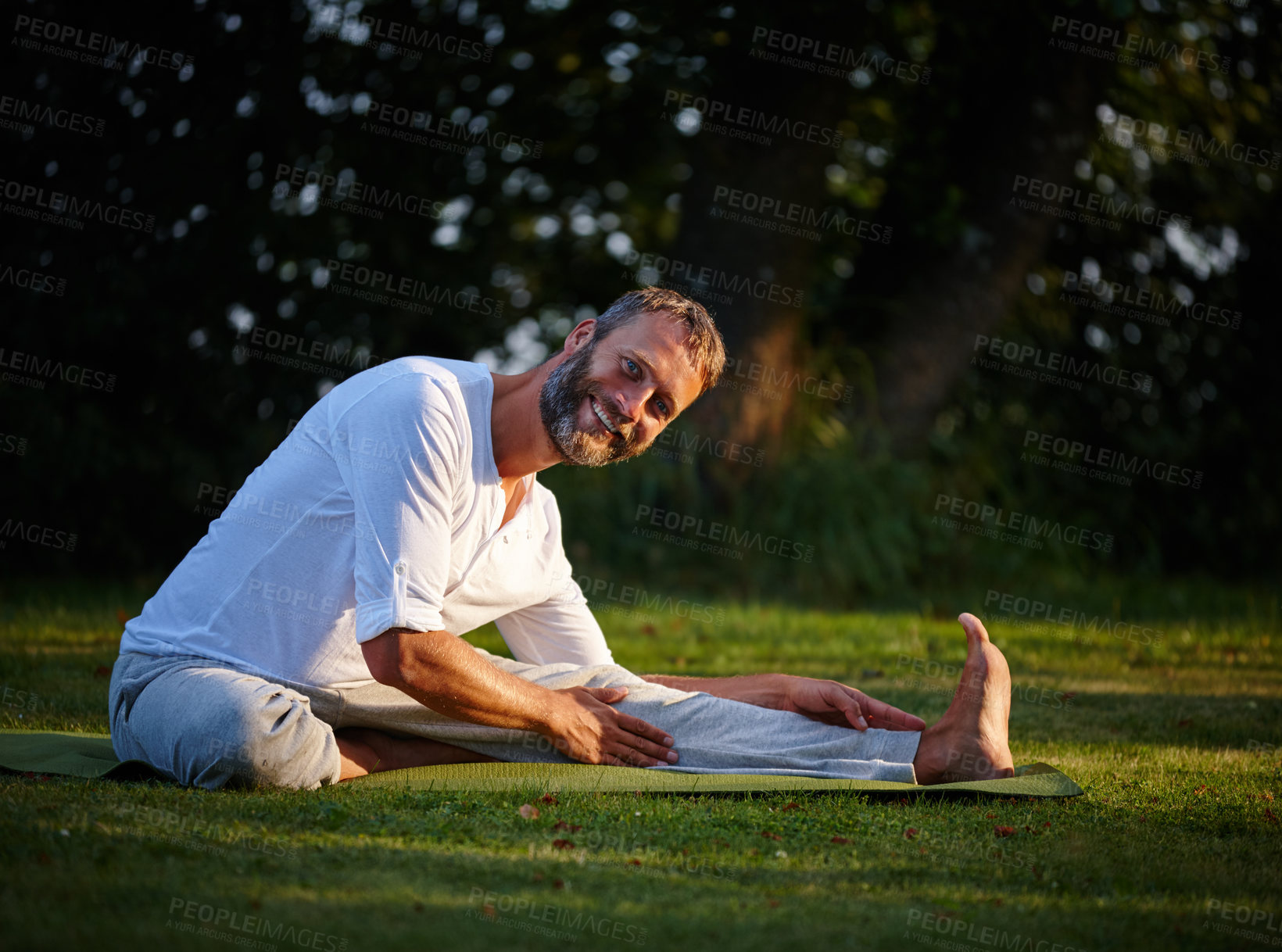 Buy stock photo Shot of a mature man doing yoga in a sitting position in the outdoors