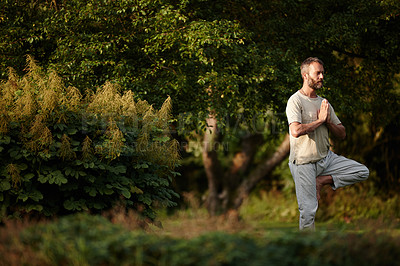 Buy stock photo Shot of a mature man doing a standing yoga pose in nature