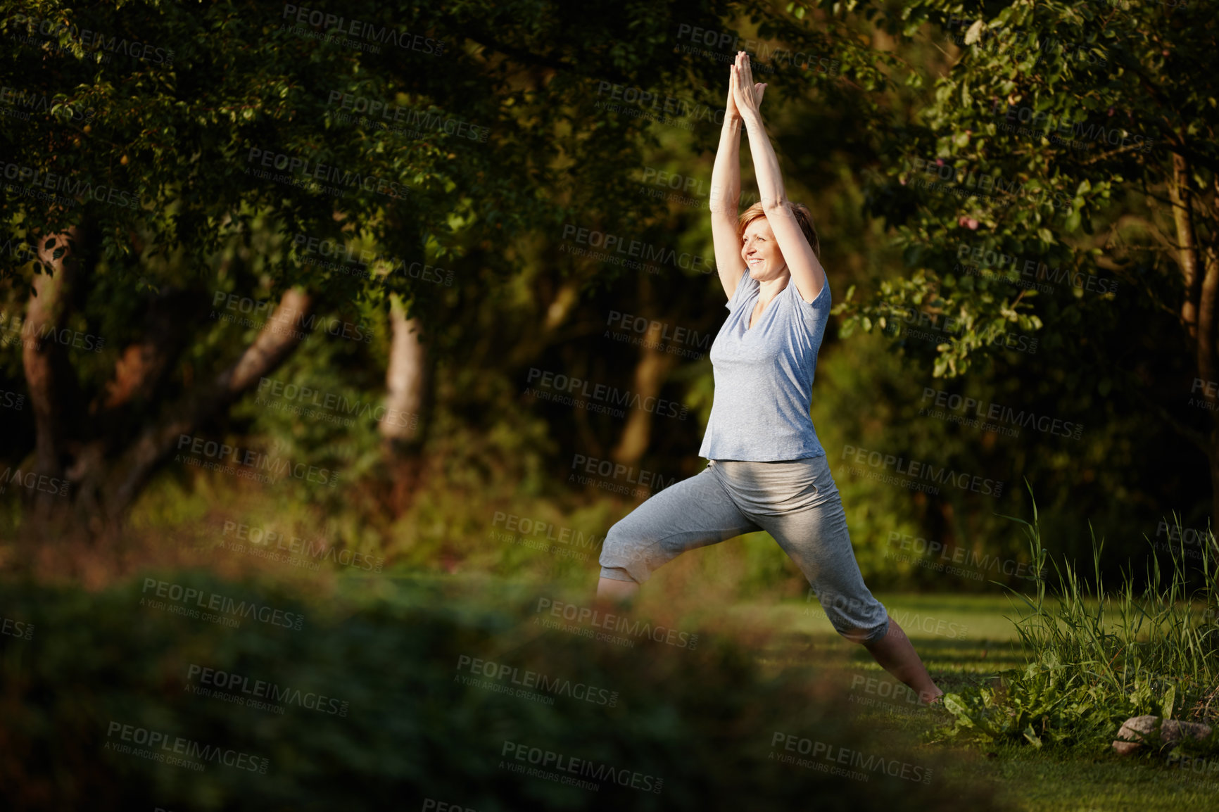 Buy stock photo Shot of an attractive woman doing yoga in the outdoors