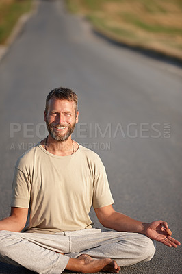 Buy stock photo Portrait of a handsome mature man sitting in the lotus position on a country road