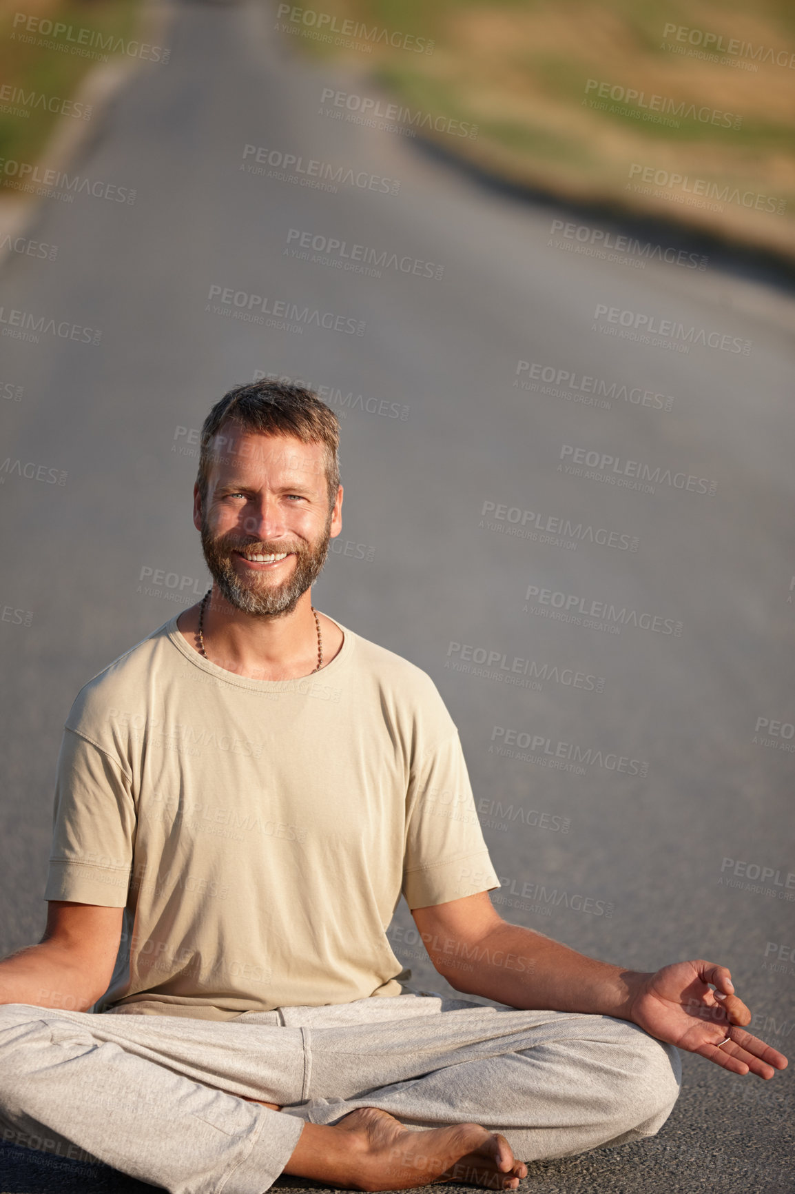 Buy stock photo Portrait of a handsome mature man sitting in the lotus position on a country road