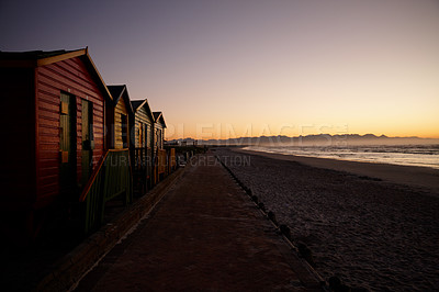 Buy stock photo Shot of an empty beach at daybreak with wooden changing huts