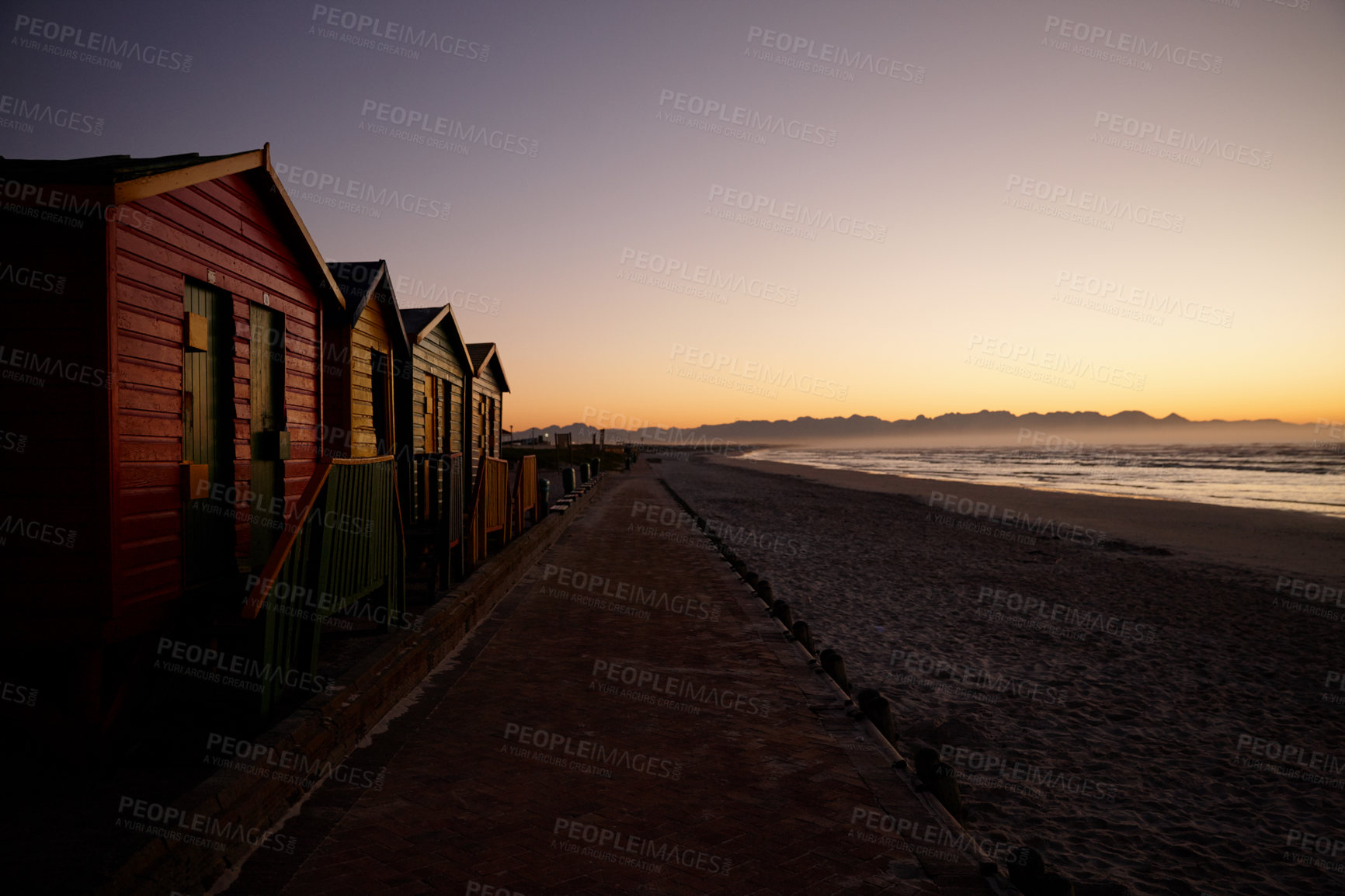 Buy stock photo Shot of an empty beach at daybreak with wooden changing huts